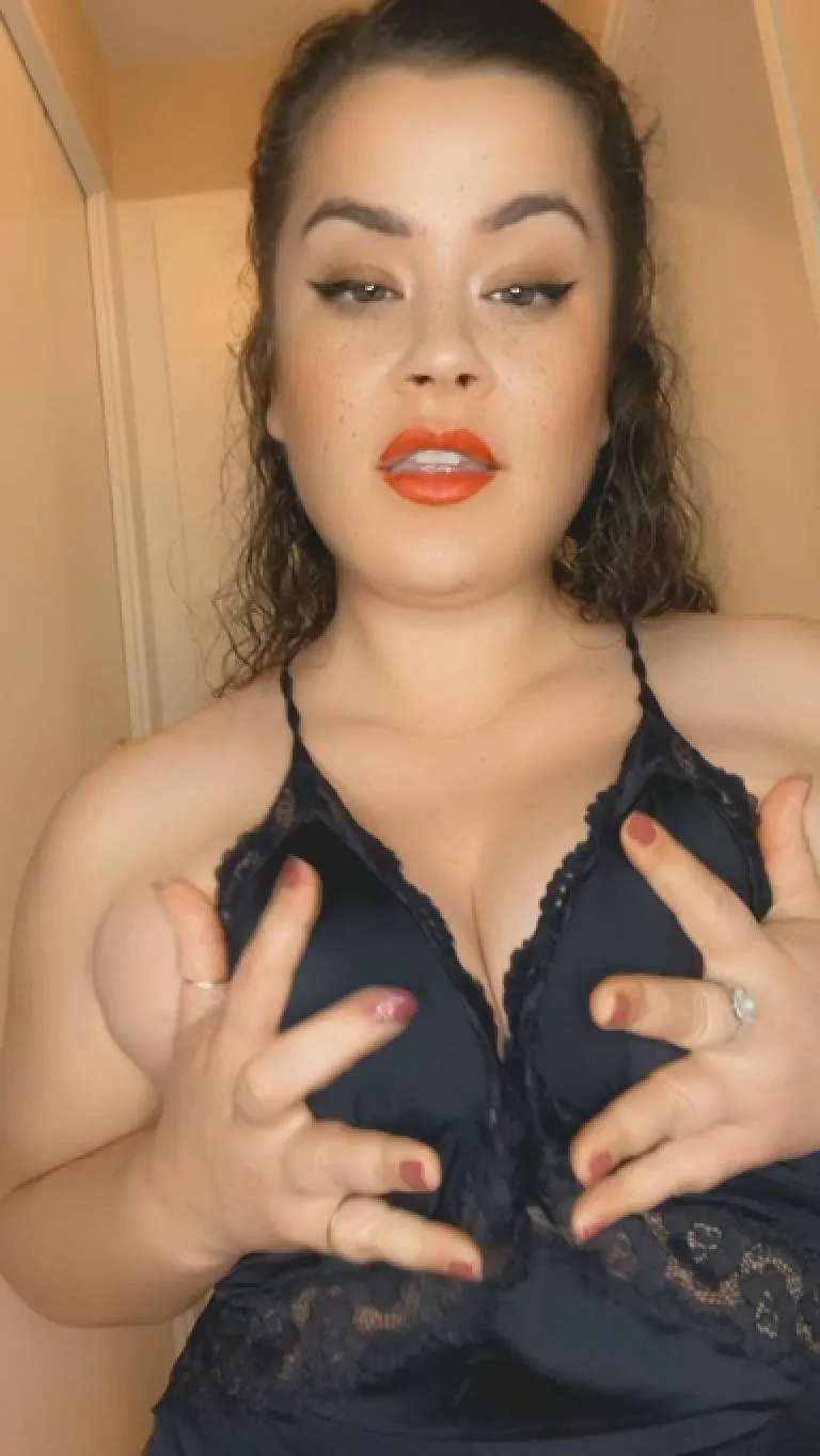 امرأة ترتدي ثوب نوم أسود تضع يديها على ثدييها